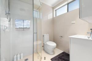 a bathroom with a toilet and a glass shower at Comfortable Home for 6 - Canberra Inner North in Belconnen +23 photos