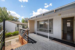 a house with a large deck in front of it at Comfortable Home for 6 - Canberra Inner North in Belconnen