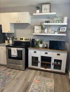 a kitchen with a stove and white cabinets at Spacious and cute basement unit in Thunder Bay +18 photos