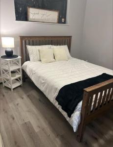 a bed with white sheets and pillows on it at Spacious and cute basement unit in Thunder Bay