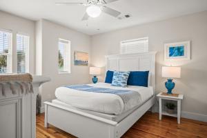 a bedroom with a white bed with blue pillows at La Concha Cottage in Port Aransas +40 photos