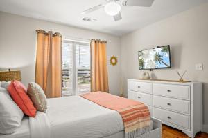 a bedroom with a bed and a dresser and a window at La Concha Cottage in Port Aransas