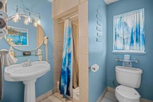 a blue bathroom with a sink and a toilet at Bluebird Day Inn & Suites in South Lake Tahoe