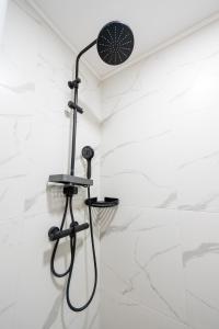 a shower in a bathroom with white marble walls at Danube Retreat in Belgrade