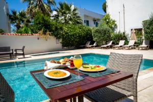 a table with food and drinks next to a pool at Porto Azul Hotel Bodrum in Bodrum City