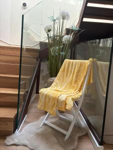 a chair with a yellow blanket sitting next to a staircase at Mercedes Etxea in Cripán