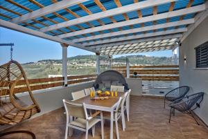 a dining room with a table and chairs on a balcony at Yourest HaAri - יורסט הארי in Safed