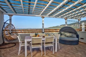 a balcony with a table and chairs and a couch at Yourest HaAri - יורסט הארי in Safed