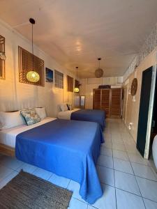 two beds in a room with blue sheets at KazParadis les Saintes in Terre-de-Haut +22 photos