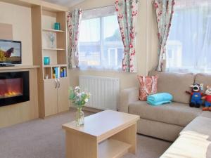 a living room with a couch and a table at 1. Forest Edge 2 Bedroom Statement Caravan in Saint Leonards
