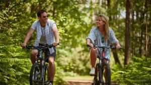a man and a woman riding bikes down a trail at 1. Forest Edge 2 Bedroom Statement Caravan in Saint Leonards
