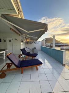 a patio with a table and chairs and an umbrella at KazParadis les Saintes in Terre-de-Haut