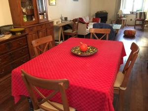 a red table with a plate with an apple on it at Maison Nancy Thermal in Nancy +1 photo
