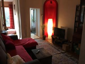 a living room with a couch and a tv at Maison Nancy Thermal in Nancy