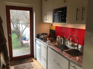 a kitchen with a sink and a door to a yard at Maison Nancy Thermal in Nancy