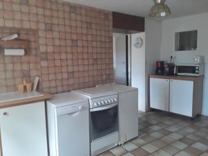 a kitchen with a stove and a white refrigerator at Maison au tilleul in Ribiers