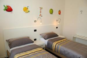 two beds in a bedroom with fruit on the wall at Villa Elisa Relax in Pozzolengo +66 photos