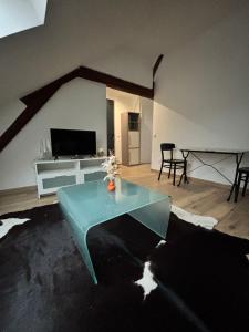 a living room with a table and a tv at Appart cosy mansardé Dijon gare 1km animaux acceptés in Dijon