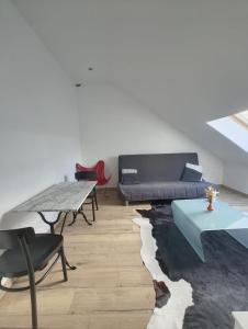 a living room with a couch and a table at Appart cosy mansardé Dijon gare 1km animaux acceptés in Dijon
