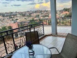 a table and chairs on a balcony with a view at Kigali Great Garden in Kigali