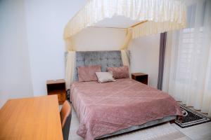 a bedroom with a bed with a canopy at Kigali Great Garden in Kigali