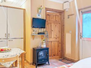 a room with a table and a television and a stove at Studio Eagle Nest by Interhome in Lettermacaward