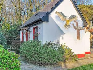 a small white house with a painting of a bird on it at Studio Eagle Nest by Interhome in Lettermacaward