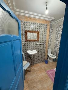 a bathroom with a blue door and a sink and a toilet at Dar kenza Tunis in Tunis +51 photos