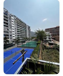 an empty tennis court in front of some buildings at E block in Rājpur
