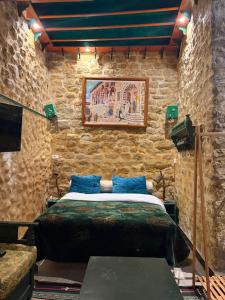 a bedroom with a bed in a stone wall at Dar kenza Tunis in Tunis