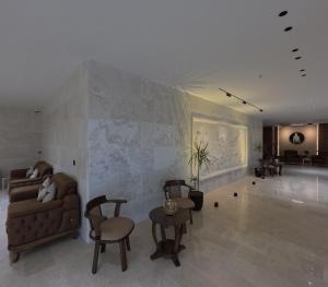 a living room with a couch and a table and chairs at Abraj Al Madina Hotel in Al Fayşalīyah