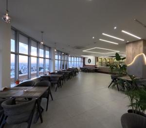 a dining room with tables and chairs and windows at Abraj Al Madina Hotel in Al Fayşalīyah