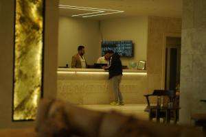 a man standing at a counter in a restaurant at Abraj Al Madina Hotel in Al Fayşalīyah