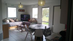 a living room with a table and a couch at Les Clés Nature Apt 44 in Moutiers-sous-Chantemerle