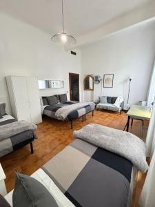a room with three beds and a couch at La Casa di Eli Appartamenti in Pisa