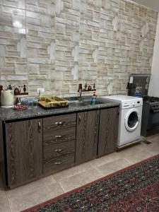 a kitchen with a sink and a washing machine at New Roman's kingdom in Madaba +16 photos