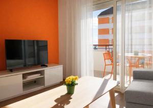 a living room with a television and a table at Beachfront apartment with sea views in Cunit