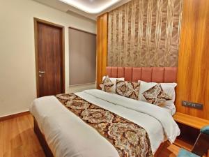 a bedroom with a large bed and a wooden headboard at Hotel Absolut Comfort 500 MTR FROM GOLDEN TEMPLE in Amritsar