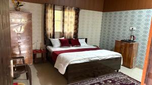 a bedroom with a large bed with red pillows at The ROYAL OASIS in Khetri