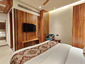 a bedroom with a bed and a tv on a wall at Hotel Absolut Comfort 500 MTR FROM GOLDEN TEMPLE in Amritsar