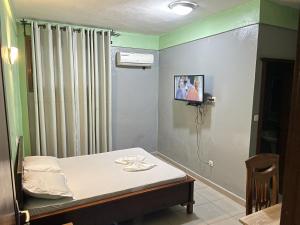 a hospital room with a bed and a television at Ngueye Hotel in Yaoundé