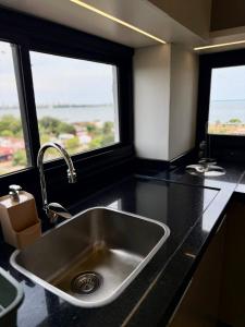 a kitchen with a stainless steel sink and two windows at Milord Suites & Apartments in Encarnación +148 photos