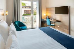 a hotel room with a bed and a desk and a window at Best Western Hotel Fontaine Argent in Besançon