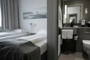 a hotel room with two beds and a sink at Hotel Vestmannaeyjar in Vestmannaeyjar