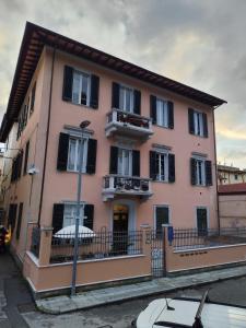 a large pink building with black shutters on a street at La Casa di Eli Appartamenti in Pisa