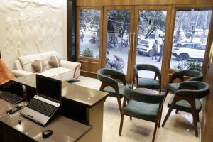 a office with a desk with a laptop and chairs at Hotel Absolut Comfort 500 MTR FROM GOLDEN TEMPLE in Amritsar