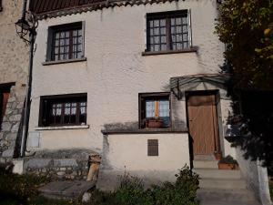 a white house with a door and a window at Maison au tilleul in Ribiers