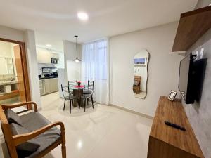 a living room with a table and a kitchen at Elohim Residencial in Rio de Janeiro