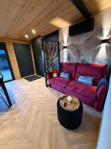 a living room with a red couch and a table at Le Petit Nid D'Amour in Évans