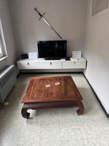 a living room with a wooden table and a tv at Repère des Templiers in Bouillon